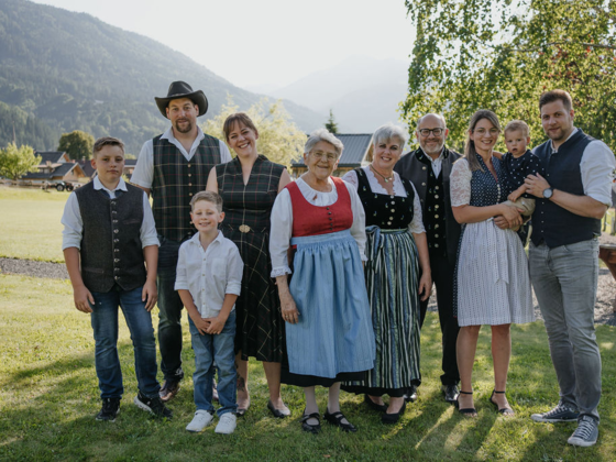 The Zerza family in traditional costume in the garden in front of the house.