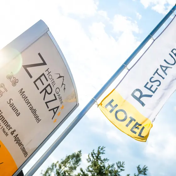 Sign and flag at the entrance to Hotel Garni Zerza.